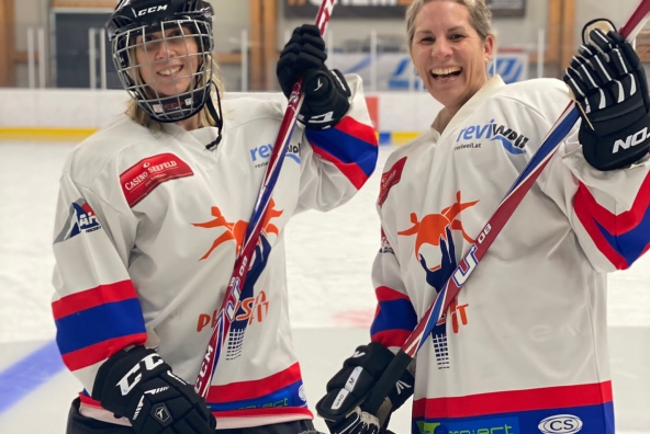 zwei BTV Mitarbeiterinnen im Eishocky Dress halten die Schläger hoch.