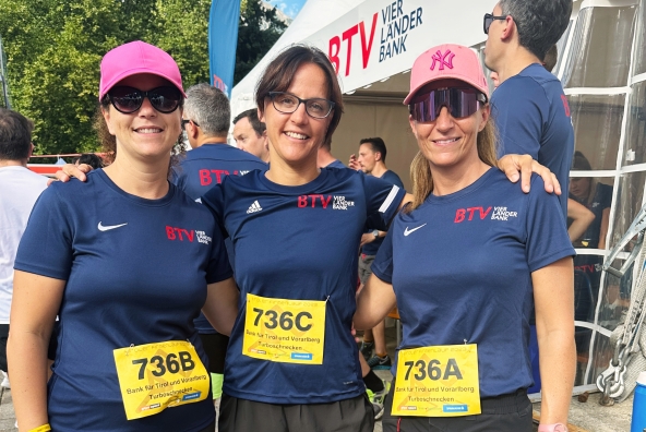 Drei BTV Mitarbeiterinnen in blauen Laufshirts beim Tiroler Firmenlauf