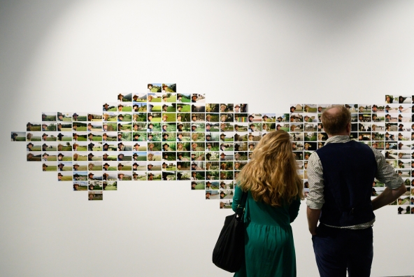 Frau und Mann betrachten Fotos in der INN SITU Galerie.